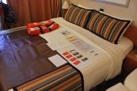 Греция - Costa Magica - так выглядят каюты с балконом в Costa Magica - на кровати разложены приветственные материалы и карточки.