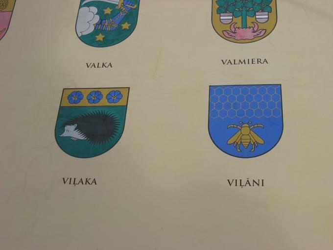 Латвия - Стена бывших казарм с гербами городов