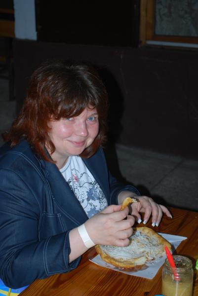 Екатерина Никитина (BSI Group) пробует Ланкос - венгерскую лепешку, которую часто готовят с луком или сыром. В готовом виде её натерают чесноком и подают к столу.