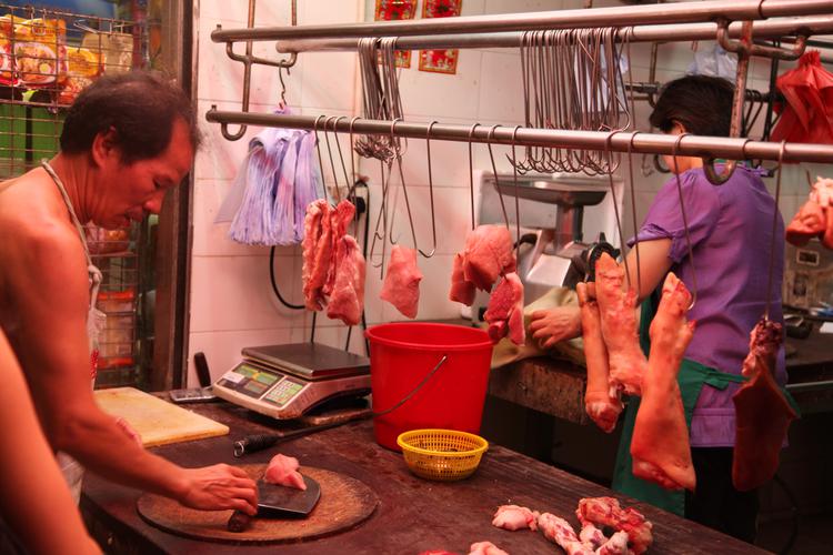 Торговец мясом на ночном рынке в Гонконге.